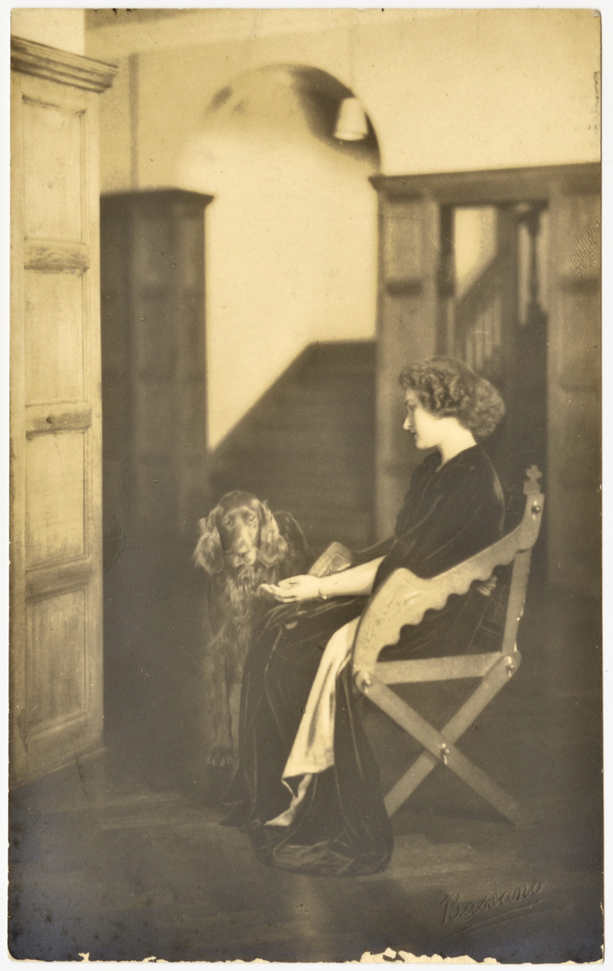 Woman sitting with dog with side to camera for formal portrait